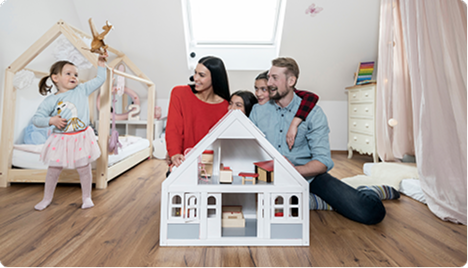 Familia jugando con la maqueta de una casa en su hogar